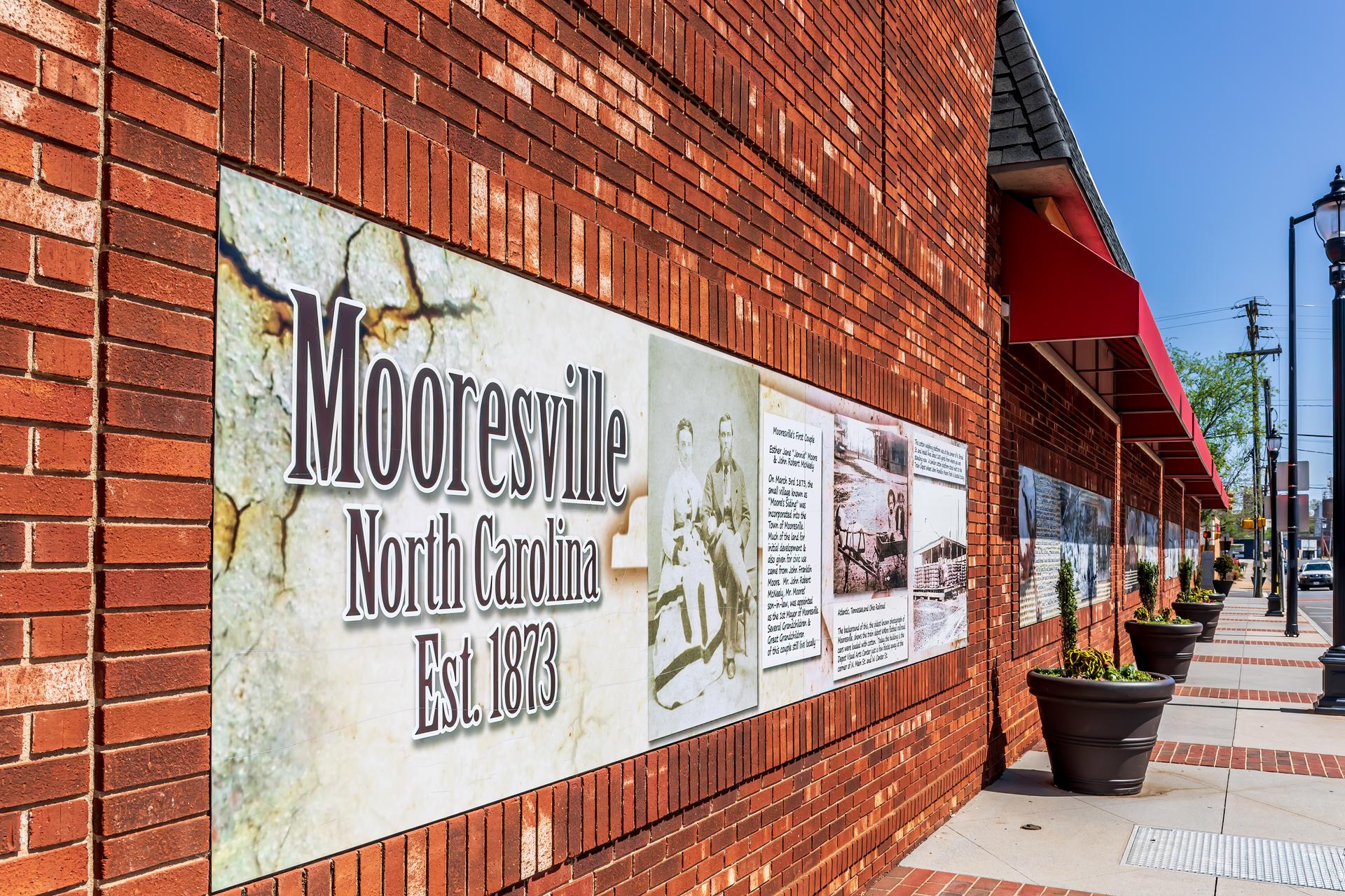 Historic photos on long brick wall, Mooresville, NC